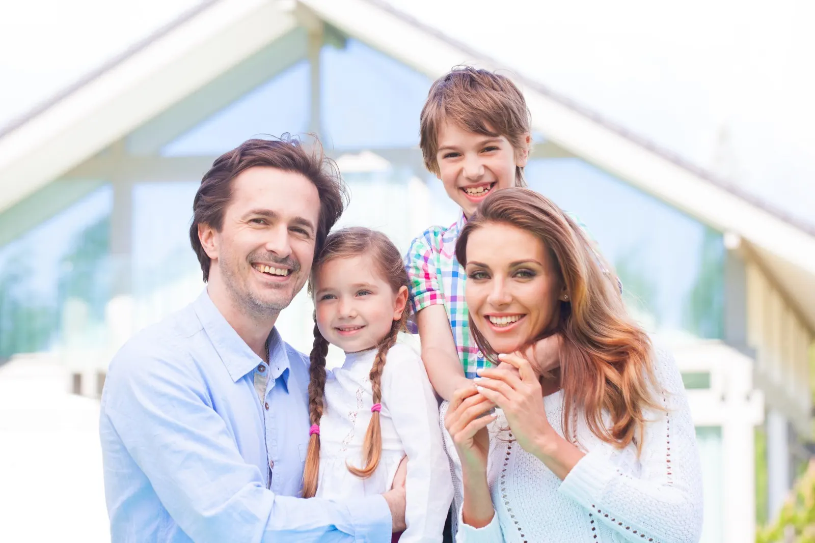 Glückliche Familie vor ihrem Haus